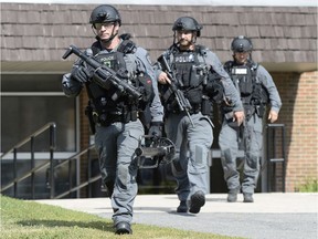 Ottawa Police tactical officers leave 1993 Jasmine Crescent after taking two people into custody, after reports of a gunshot this morning, in Ottawa on Tuesday, August 2, 2016.