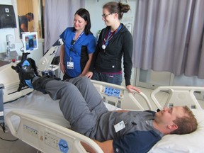 Physiotherapists Josée Lamontagne (left) and Rachel Goard supervised while Respiratory Therapy student Patrick Lapointe demonstrated the specially-designed bicycle at the Ottawa General Campus ICU.