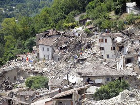 Rescuers search through debris of collapsed houses following an earthquake in Pescara del Tronto, Italy, Wednesday.