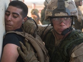 A member of the 2e Bataillon, Royal 22e Régiment, arrests a mock aggressive protester during non-combatant evacuation operations training during RIMPAC 2016 at Camp Pendleton in San Diego, California on July 28, 2016.

Photo by: Sgt Marc-André Gaudreault, Valcartier Imaging Services
VL08-2016-0020-185