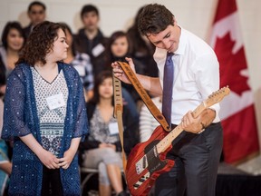 Kristin Albert presents Prime Minister Justin Trudeau with a guitar built by students as a gift while visiting Oskayak High School in Saskatoon, Sask., Wednesday, April 27, 2016.