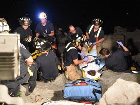 Rescue teams crowd around a 22-year-old man who suffered non-life-threatening injuries in a fall under the Portage Bridge Monday night. Scott Stilborn via Twitter
