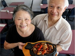 Singapore owner Ah Bah Lim and his wife, Hsiao Foo Huang, hold a plate of Sizzling Onion Beef.