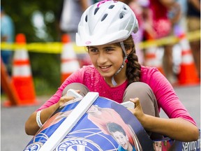 Syrian refugee Aziza Toubeh pilots her soapbox down Beaverwood Road during the sixth annual soapbox derby in Manotick on Sunday, Aug. 28, 2016.