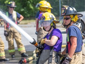 Tess Armstrong, 19, of Montreal aiming the fire hose as young women learn firefighting skills during Camp FFIT (Female Firefighters in Training).