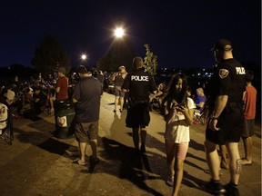 Two police officers walk through a crowd of Pokemon Go players at Dick Bell Park on Wednesday.