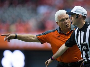 B.C. Lions' head coach Wally Buono, left, protests a call to an official during the first half of a CFL football game against the Calgary Stampeders in Vancouver, B.C., on Friday August 19, 2016.
