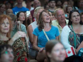 A woman sings along during a viewing party for the final stop in Kingston of a 10-city national concert tour by The Tragically Hip, in Vancouver, B.C., on Saturday August 20, 2016.