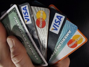 In this March 5, 2012, file photo, consumer credit cards are posed in North Andover, Mass. Statistics Canada says the ratio of household credit market debt to disposable income edged down in the first quarter.