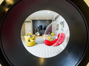 Play room: The play room offers lots of choices for kids, from a climbing wall by Rock Werx to a music stage, their own TV and a funky circular hanging acrylic chair beside a round cut-out looking to the pool table next door and framed with a circular bookcase.