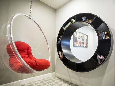 Play room: The play room offers lots of choices for kids, from a climbing wall by Rock Werx to a music stage, their own TV and a funky circular hanging acrylic chair beside a round cut-out looking to the pool table next door and framed with a circular bookcase.