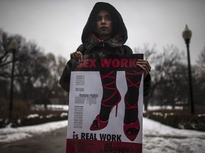 In this 2013 file photo, a woman holds a sign during a rally to support sex workers' rights.