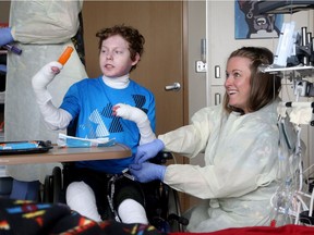 After a draining round of radiation, Jonathan Pitre finds delight in a simple popsicle while getting checked on by nurses at the University of Minnesota Masonic Children's Hospital Wednesday.