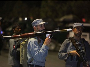 An Afghan policeman holds a rocket-propelled grenade launcher at the site of a complex Taliban attack on the campus of the American University in the Afghan capital Kabul on Wednesday, Aug. 24, 2016.