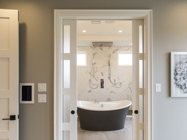 Ensuite: The ensuite is a ‘shower experience,’ says designer Donna Correy. The walk-through shower stretches from one end of the room to the other and features double transom windows that flood the space with natural light, ‘an incredible rainshower system on the ceiling’ where you can dial the kind of rain you want from a mist to a storm, and a glass wall, yet to be installed, that will separate the shower from the standalone tub in front of it. Double vanities with waterfall quartz counters offer his-and-hers pampering.