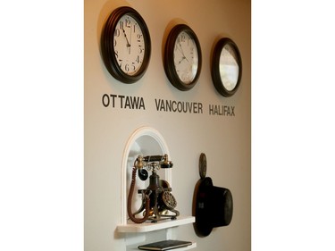 An old phone and clocks which show the time where some of her family live, complete one of the walls off the entryway.