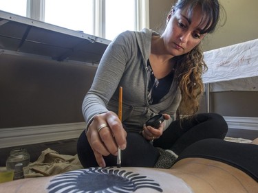 Artist May Mutter in the early stages of creating a full-body painting on Marie-Claude Messier. Both women have suffered serious concussions. (Bruce Deachman, Ottawa Citizen)