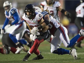 Ottawa Redblacks wide receiver Brad Sinopoli is tackled by Montreal Alouettes linebacker Bear Woods (48) during first half CFL football action, in Montreal on Thursday, September 1, 2016.