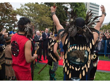 Prince William the Duke of Cambridge (4L) and Canada's Governor General David Johnston (3L)  watch First Nations traditional dancers in front of the Legislative Assembly in Victoria, British Columbia on September 24, 2016. The prince and his wife first visited Canada five years ago. This time they will take in the natural beauty of Canada's Pacific coast, heading as far north as the rugged Yukon territory, and will also meet with indigenous people. /
