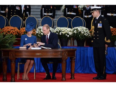 Catherine the Duchess of Cambridge (L) and Prince William the Duke of Cambridge sign the Canadian government's Golden Book at the Legislative Assembly in Victoria, British Columbia on September 24, 2016. The prince and his wife first visited Canada five years ago. This time they will take in the natural beauty of Canada's Pacific coast, heading as far north as the rugged Yukon territory, and will also meet with indigenous people. /