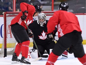 Team Canada's Carey Price deflects a shot from Sidney Crosby, right, as Patrice Bergeron looks on during practice in Ottawa on Tuesday, Sept. 6, 2016, in preparation for the World Cup of Hockey.
