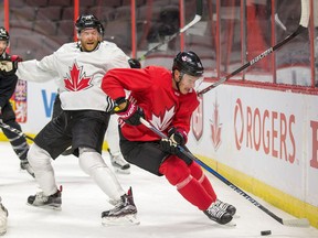 Claude Giroux (L) and Jonathan Toews (R) battle for the puck as Team Canada practices at Canadian Tire Centre in preparation for the World Cup of Hockey Tournament.