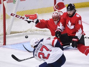 Team Canada goaltender Corey Crawford dives to make a save as teammate Drew Doughty defends against Team USA's Ryan McDonagh during the third period in pre-tournament World Cup of Hockey action in Ottawa on Saturday, Sept. 10, 2016.