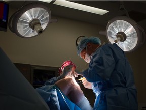 Doctors remove a cyst from a patient's knee at the Cambie Surgery Centre in Vancouver. Dr. Brian Day is at the British Columbia Supreme Court fighting for the private clinic's right to exist. Opponents accuse him of trying to undermine Canada's publicly funded medical system.