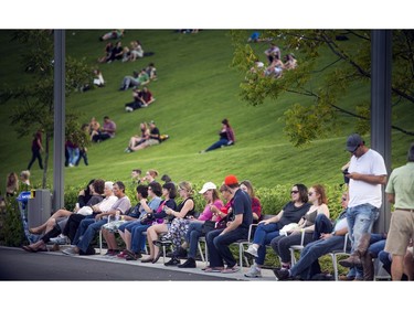 Early festival-goers relax and take in the music on the great lawn at Lansdowne Park on Sunday, Sept. 18, 2016.