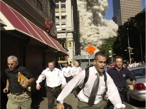FILE - In this Sept. 11, 2001 file photo, people run from a collapsing World Trade Center tower in New York.