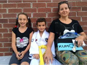 Nawal Zayat sits with her children Sarah and Fidel outside the building where they to to taekwon-do clases and tutoring. She's upset abut the pot shop that opened in the same building on St. Joseph Boulevard in Orleans.