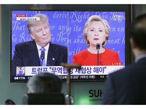 People watch a TV screen showing the live broadcast of the U.S. presidential debate between Democratic presidential nominee Hillary Clinton and Republican presidential nominee Donald Trump, at Seoul Railway Station in Seoul, South Korea, Tuesday, Sept. 27, 2016.