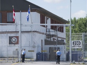 Guards stand outside the gates of an immigrant holding centre in Laval, Que., Monday, August 15, 2016. Immigration holding facilities in Vancouver and Laval, Que., will be replaced as part of a $138-million overhaul intended to improve detention conditions for newcomers to Canada, according to Public Safety Minister Ralph Goodale.