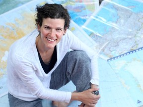 Jennifer Kingsley sits on a pile of navigational charts she used on her travels north. The Ottawa writer has teamed up with a photographer to compile a web-based project called Meet the North.
