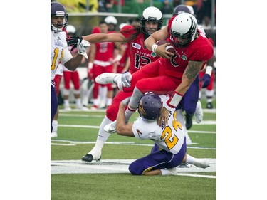 Jesse Mills of the Carleton Ravens gets stopped by Scott Hutter of the Laurier Golden Hawks.