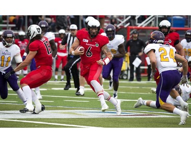 Jesse Mills of the Carleton Ravens runs to an opening against the Golden Hawks.