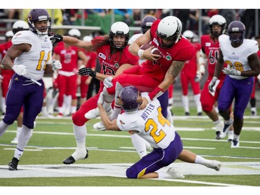 Jesse Mills of the Carleton Ravens tries to get past Scott Hutter of the Laurier Golden Hawks.