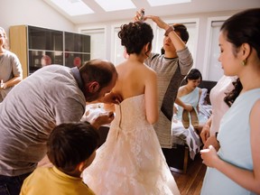 Jo Du is helped with her wedding dress in Cambridge, Ont., on Sunday, Sept.25, 2016.