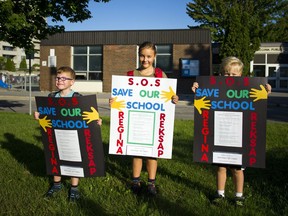 L-R Six year old Ryan Aikin, Nine year old Anna Weatherup and Seven Adam Weatherup hold up "save our school" signs outside Regina Street Public School Tuesday September 6, 2016.   Photos by Ashley Fraser
