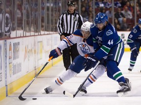 Vancouver Canucks' Matt Bartkowski, right, checks Edmonton Oilers' Leon Draisaitl, of Germany, during the first period of a pre-season NHL hockey game in Vancouver, B.C., on Saturday October 3, 2015.