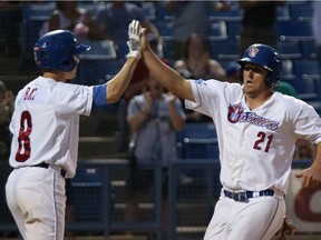 Matt Helms (21) of the Ottawa Champions celebrates his run with Daniel Bick against the New Jersey Jackals at the Raymond Chabot Grant Thornton Park in Ottawa, September 07, 2016.