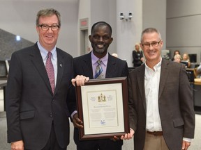 (L to R) Mayor Jim Watson, Rev. Joseph Kiirya and Knoxdale-Merivale Coun. Keith Elgi pose with the Mayor's City Builder Award on Wednesday, Sept. 14, 2016.