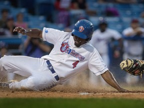 Ottawa Champions' Albert Cartwright slides past the glove of Richard Stock of the New Jersey Jackals for the first run of the game during first-round playoff action at the Raymond Chabot Grant Thornton Park in Ottawa, September 8, 2016.