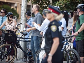 Ottawa Police and onlookers at the site where a cyclist died in a collision with a truck at Laurier Avenue and Lyon Street Thursday morning.