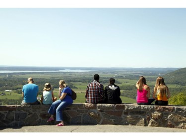 People sit and enjoy a popular lookout spot in Gatineau Park.
