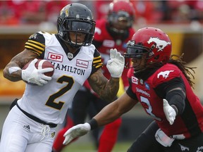 Hamilton Tiger-Cats Chad Owens avoids a tackle by Taylor Reed of the Calgary Stampeders during CFL football in Calgary, Alta., on Sunday, August 28, 2016.
