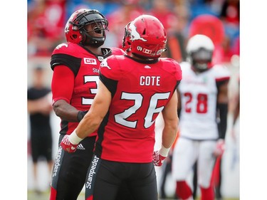Calgary's Jerome Messam celebrates with teammate Rob Cote after his touchdown against the Ottawa Redblacks.
