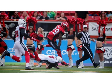 The Calgary Stampeders' Jamar Wall leaps over quarterback Trevor Harris after his interception for a touchdown against the Ottawa Redblacks.