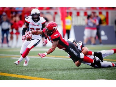 The Calgary Stampeders' Marquay McDaniel reaches for a touchdown against Nick Taylor and Antoine Pruneau of the Ottawa Redblacks.