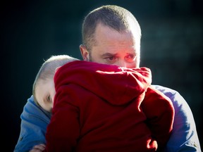RCMP Const. Sarah Beckett's husband, Brad Aschenbrenner, and one of their sons, Emmit Aschenbrenner, are seen at a ceremony honouring them on Parliament Hill on Saturday, Sept. 24, 2016. Beckett was killed in a crash in Langford, B.C., on April 5, 2016. She was 32.
